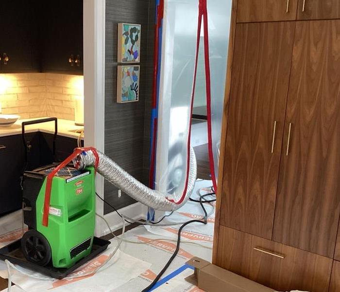 Dehumidifier and containment setup in a kitchen. 