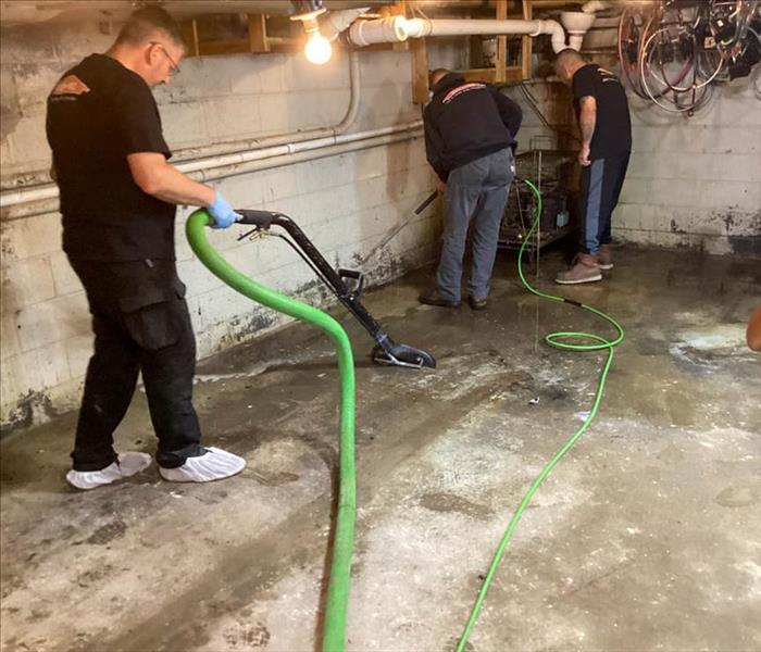 Team members extracting water from a basement.